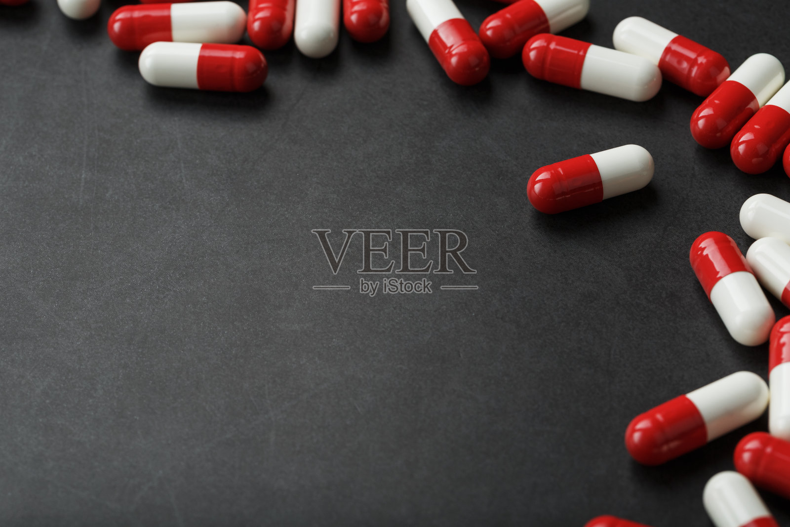 带有药物的药丸散落在黑色背景上照片摄影图片