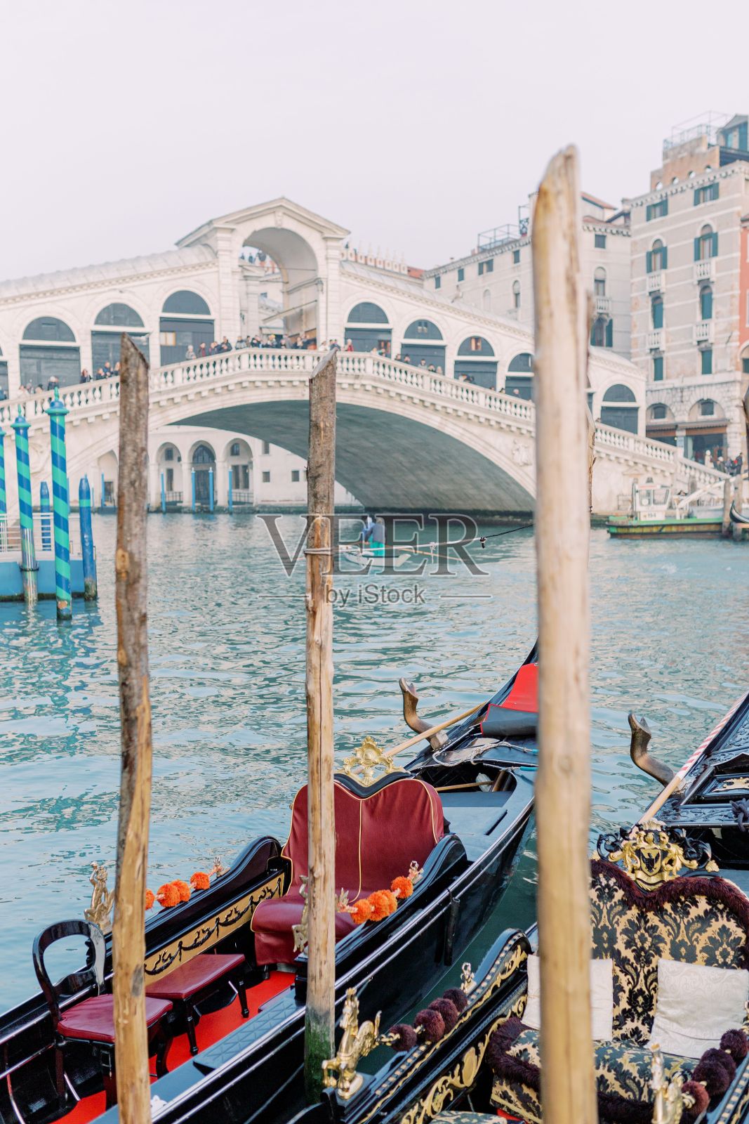 一艘贡多拉停靠在蔚蓝的海水中，在里亚托桥附近等待下一位乘客。照片摄影图片