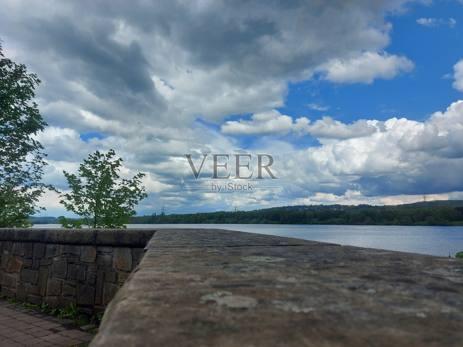 天空，移动的云，树木，湖泊和石头照片摄影图片
