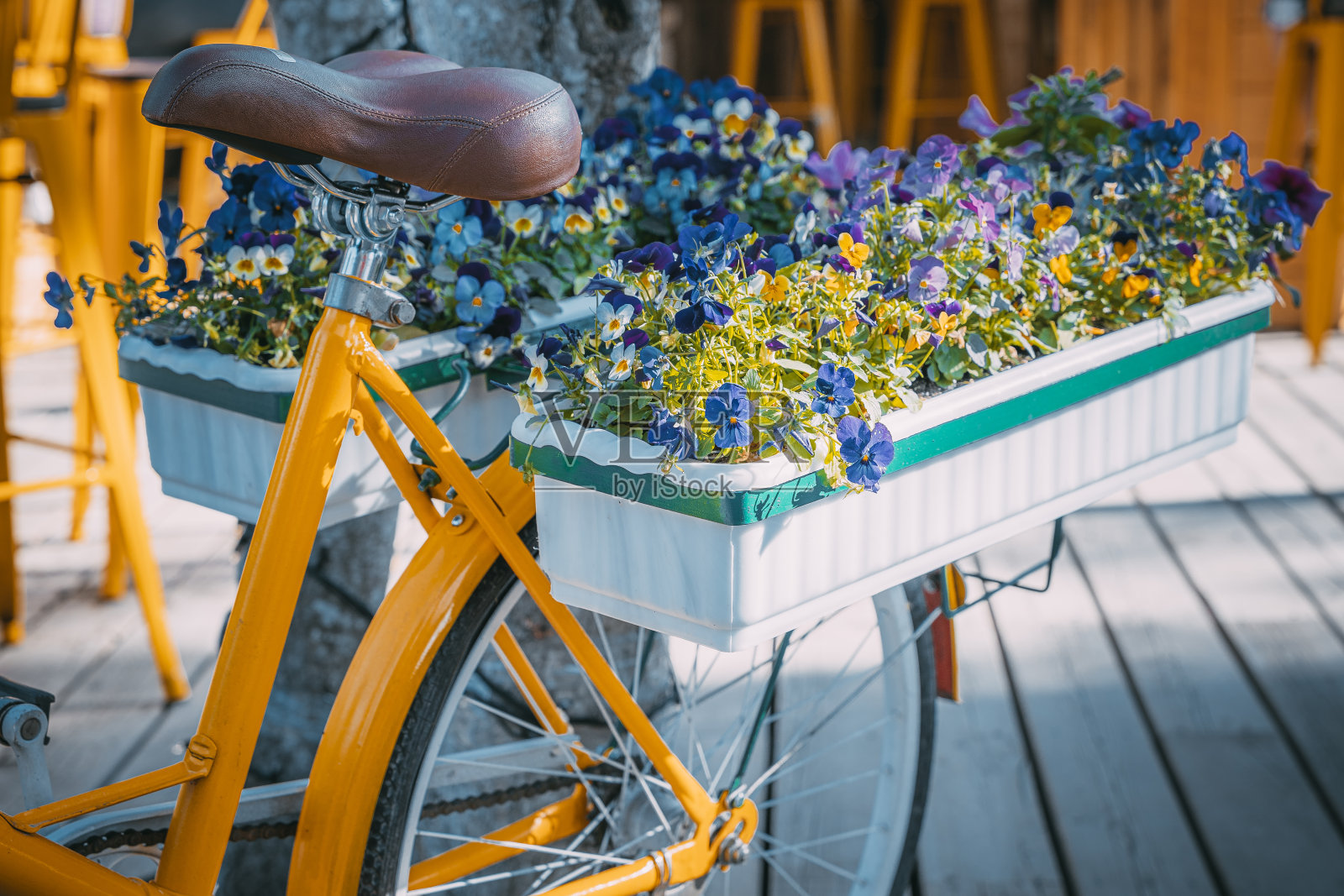 黄色女士复古自行车和装饰街道的花盒照片摄影图片