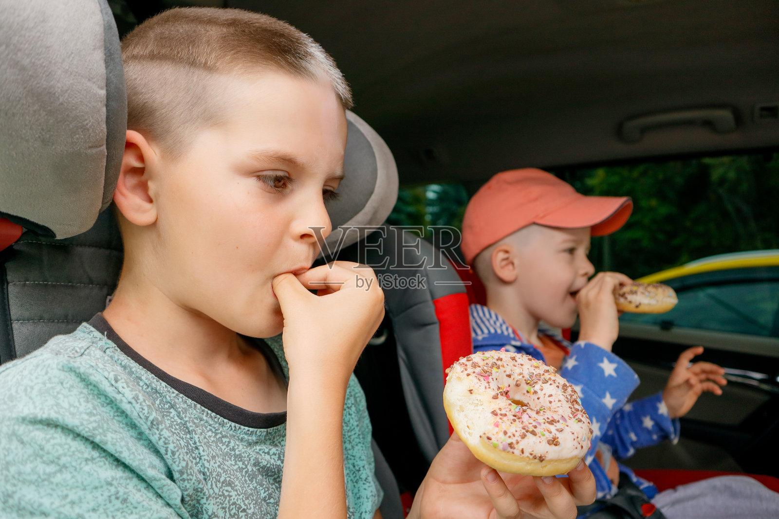 两个男孩在车里吃甜甜圈照片摄影图片