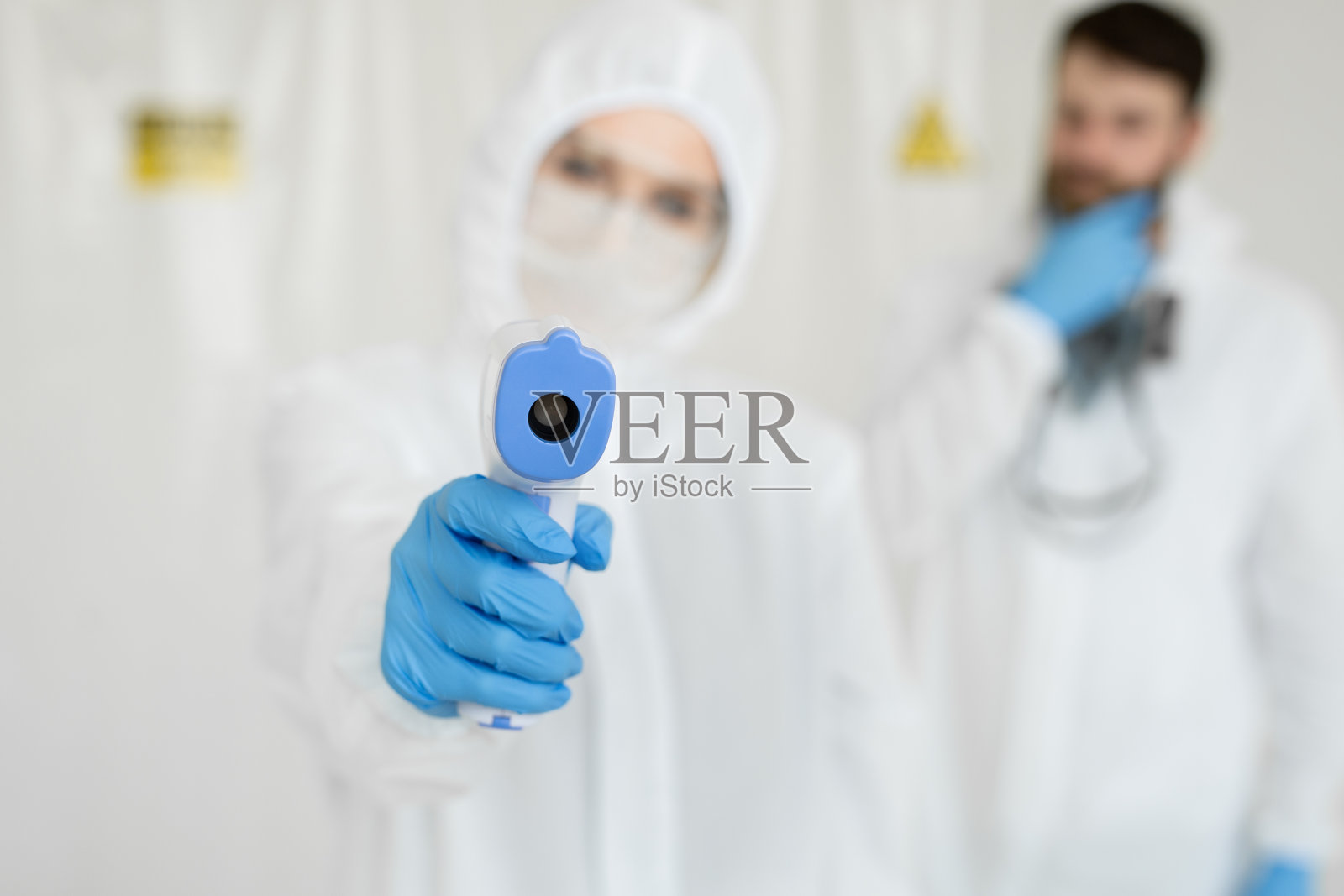 穿着防护服的医务人员在Covid-19检测中心测量非接触性发热照片摄影图片