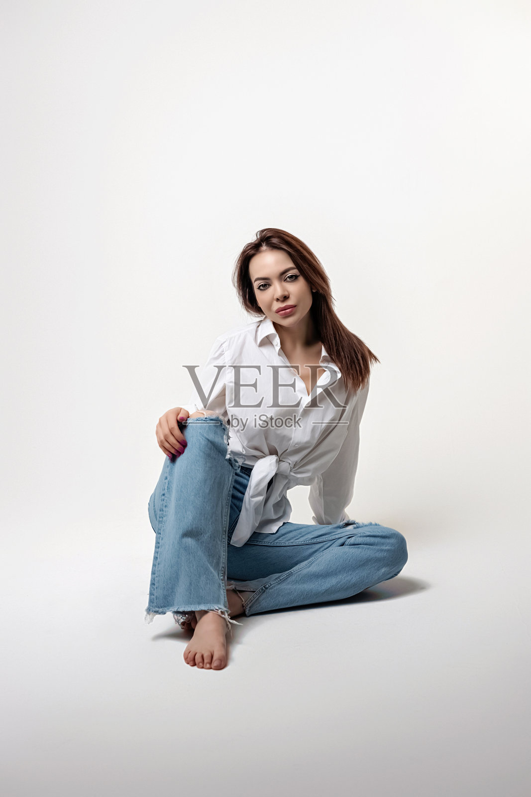 一个美丽性感的黑发长发，身穿黑色紧身衣、夹克和靴子，在白色背景上摆姿势。工作室拍摄照片摄影图片