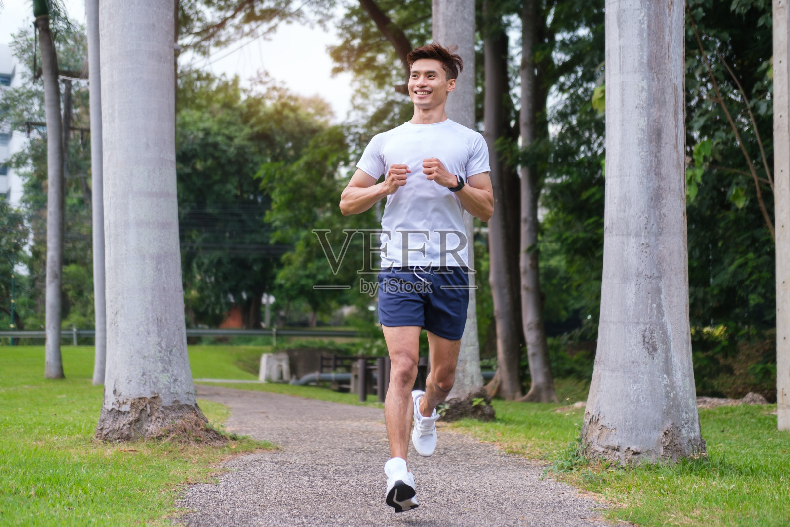 穿着运动服在公园慢跑的男子全身照片。照片摄影图片