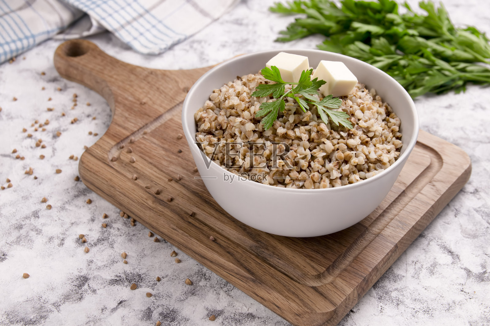 刚煮好的荞麦粥放在盘子里，背景是灰色的。照片摄影图片