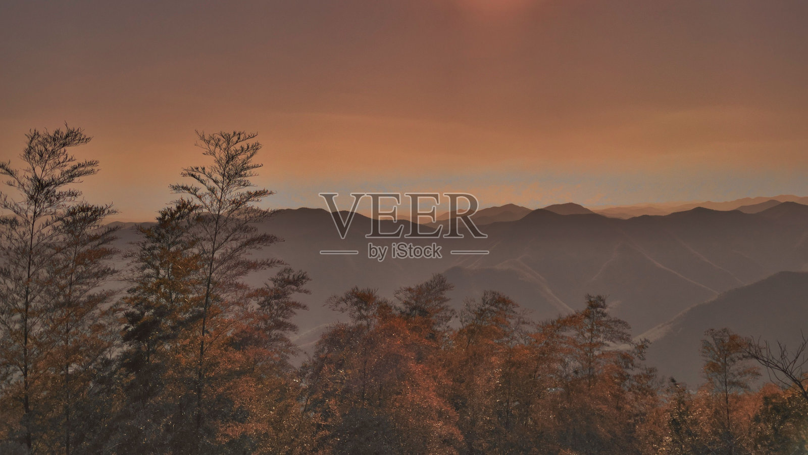 日落时分，岩石悬崖顶上的雪山和蓬松白云照片摄影图片