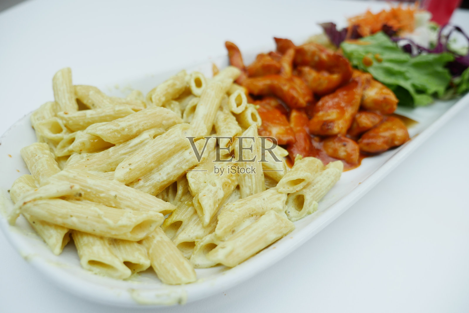 意大利面，鸡肉和新鲜的沙拉放在盘子里照片摄影图片