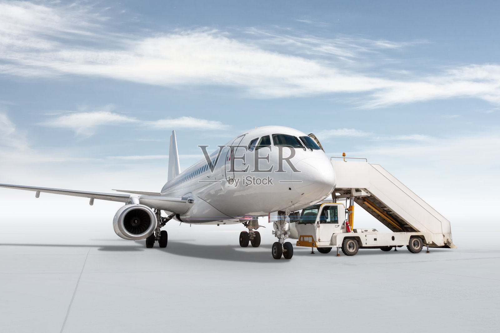 白色的客机与明亮的天空背景隔着一个登机台阶照片摄影图片