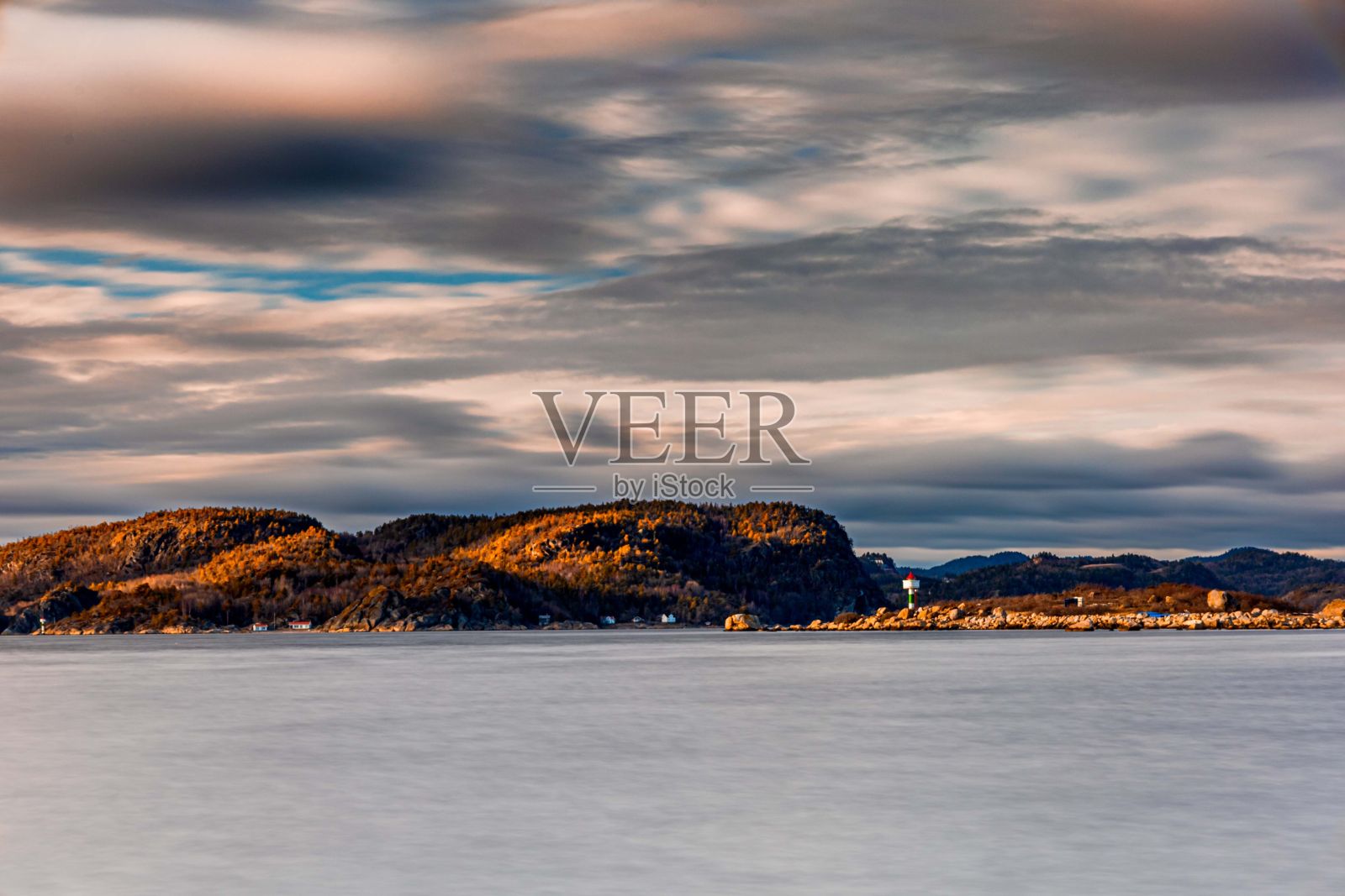 阴天的海岸和背景中的灯塔照片摄影图片