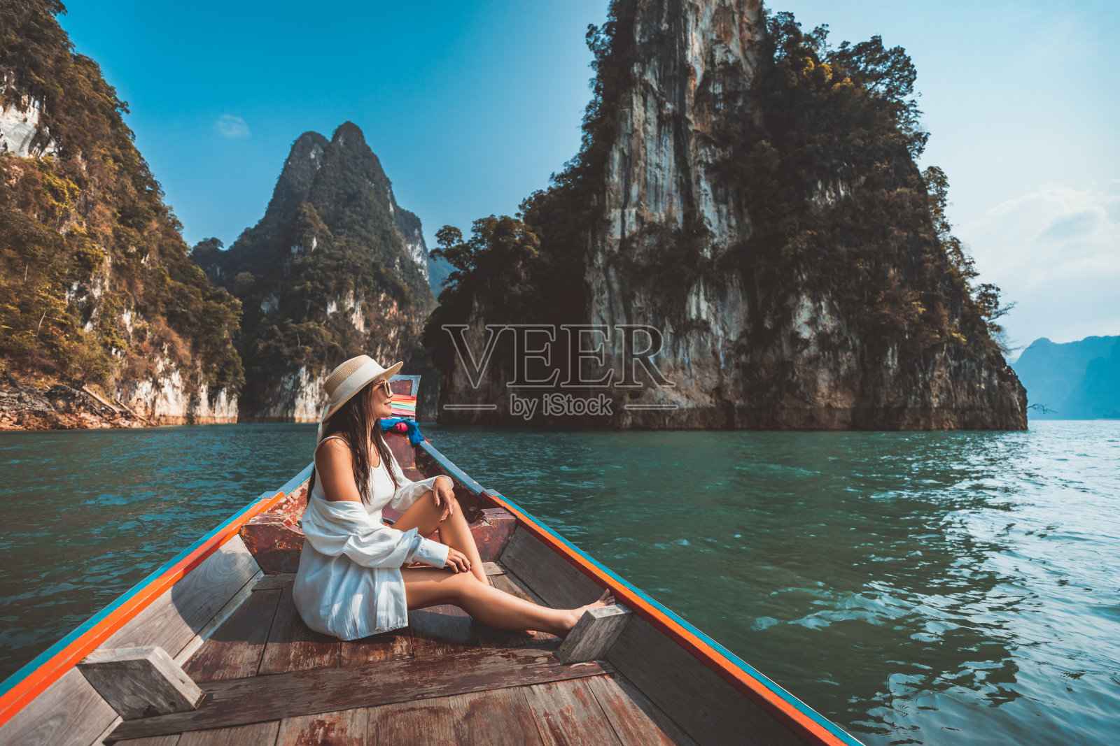 在泰国素叻他尼考索国家公园的Ratchaprapha大坝上，亚洲游客在泰国长尾船上放松和旅行照片摄影图片