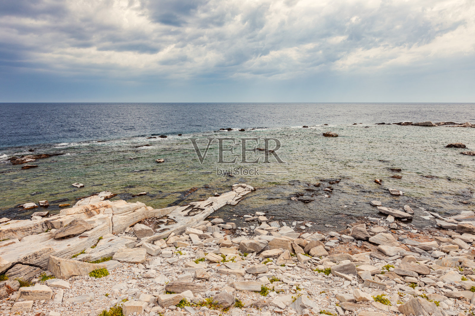 岩石海岸的迷人景色，多云的天空充满了黑暗的风暴云照片摄影图片