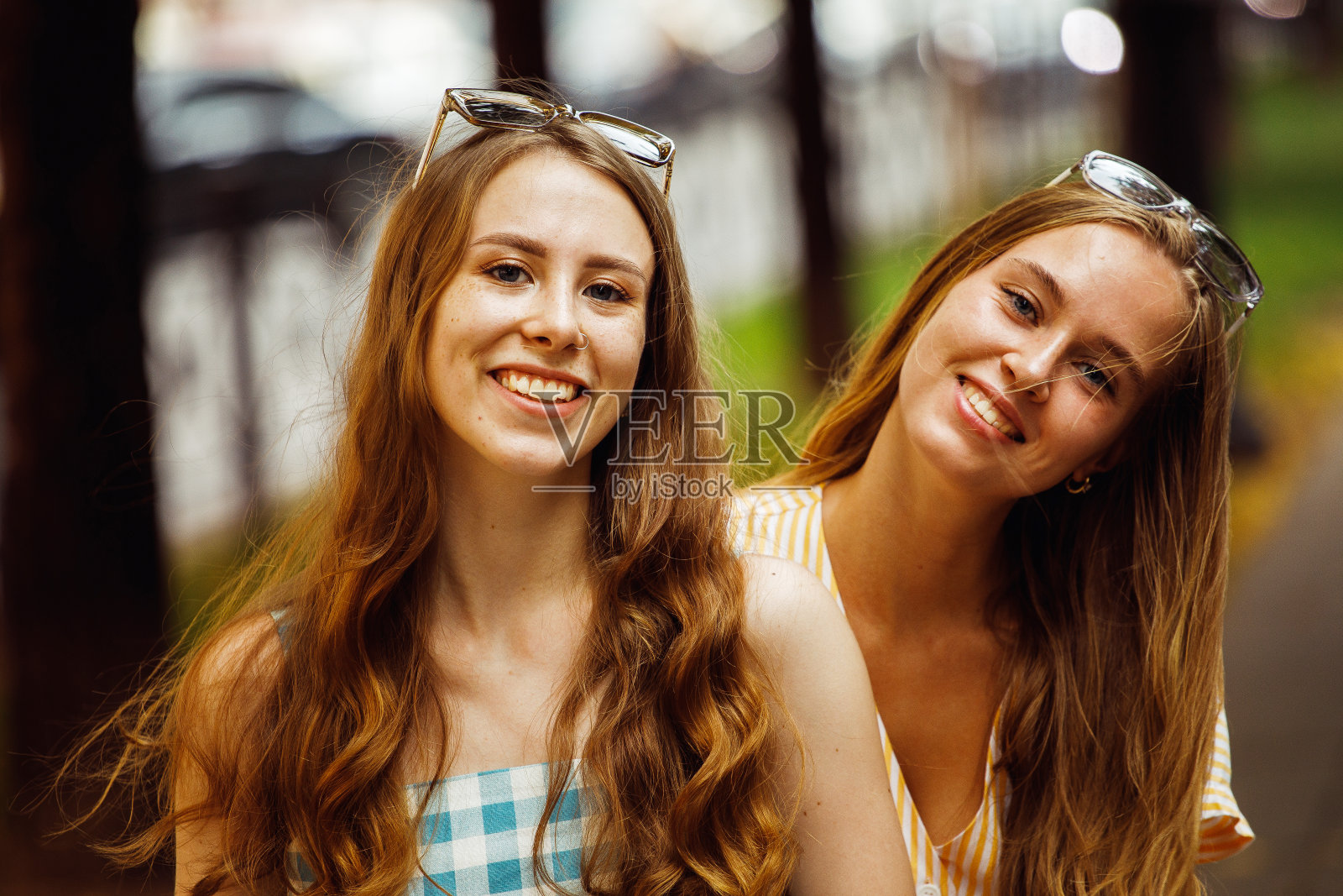 城市户外的年轻女性朋友。他们在夏天日落时坐着聊天照片摄影图片