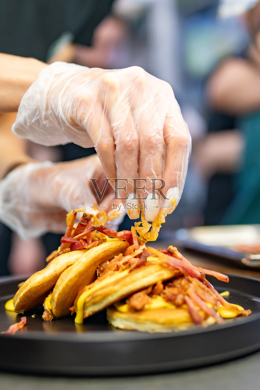 女厨师用手用肉、培根和奶酪酱做煎饼照片摄影图片
