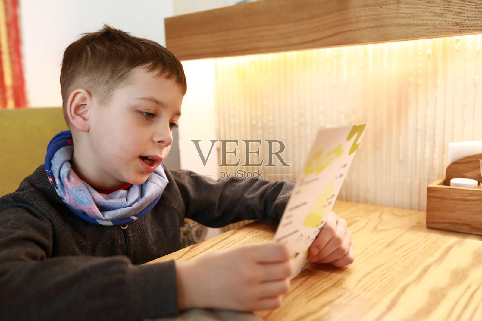 孩子根据菜单选菜照片摄影图片