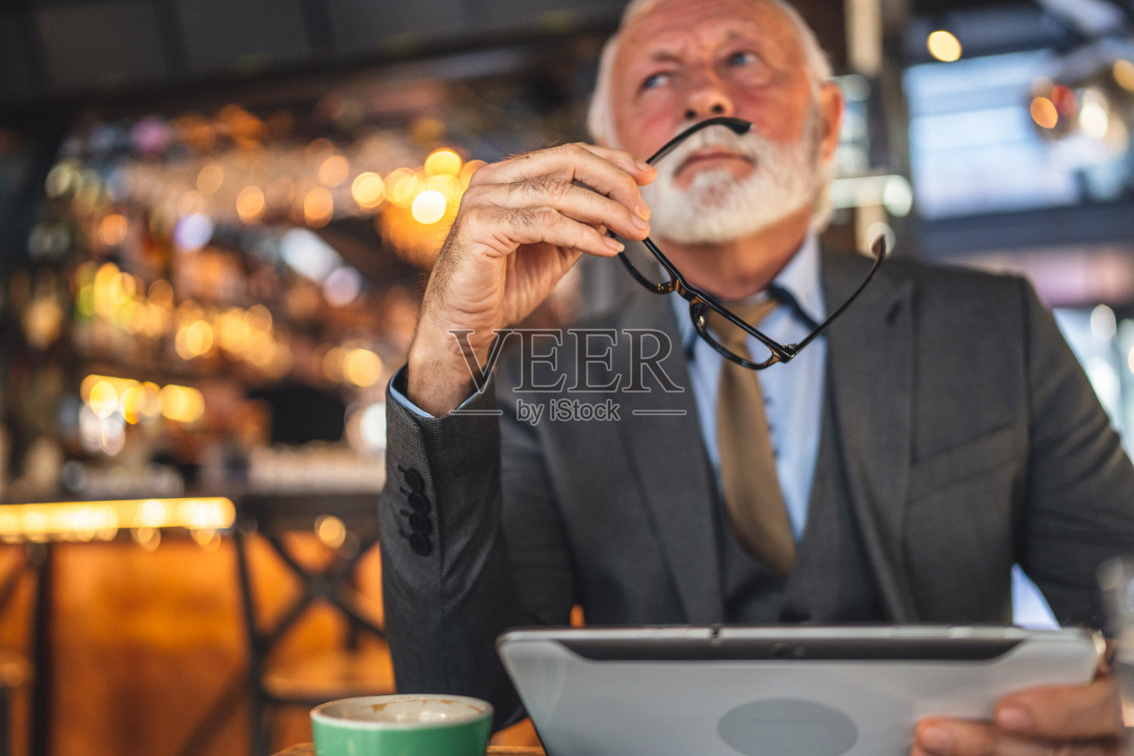 高级男子商人企业主坐在咖啡馆使用数码平板电脑照片摄影图片