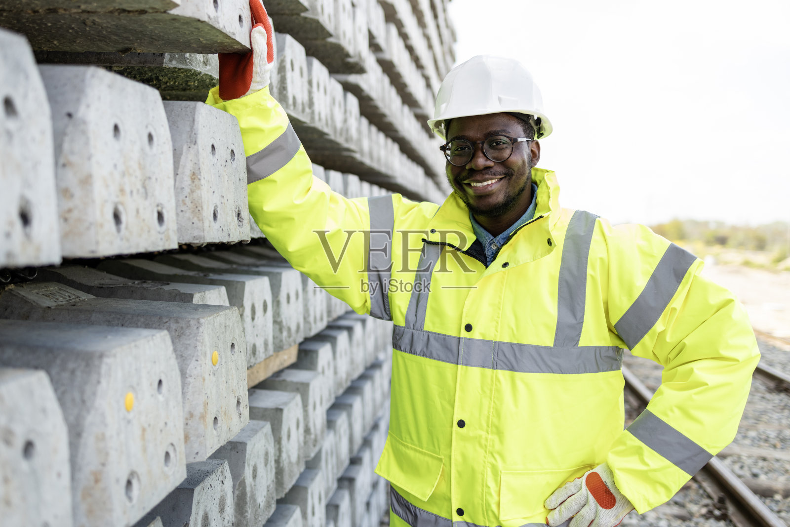 铁路建筑工人站在混凝土枕木旁的肖像。照片摄影图片