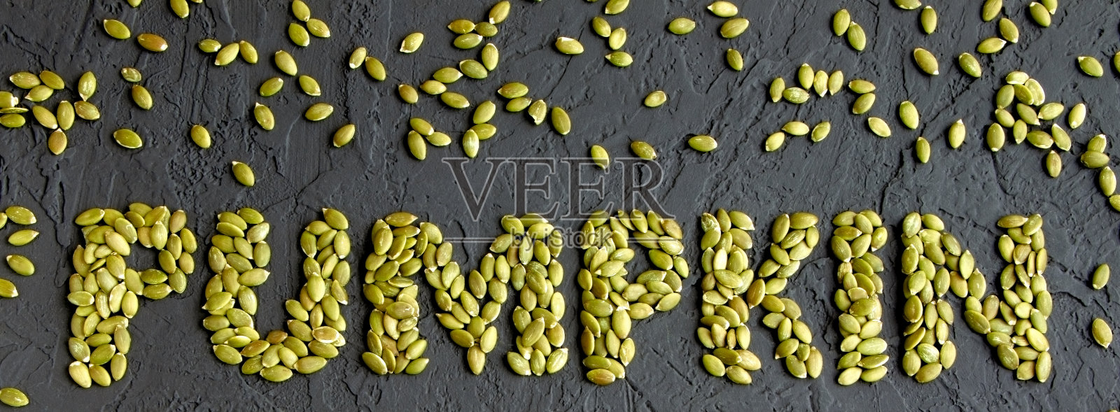 黑底上的南瓜籽。去皮南瓜种子。健康食品。超级食物。撒下的南瓜种子。平躺照片摄影图片