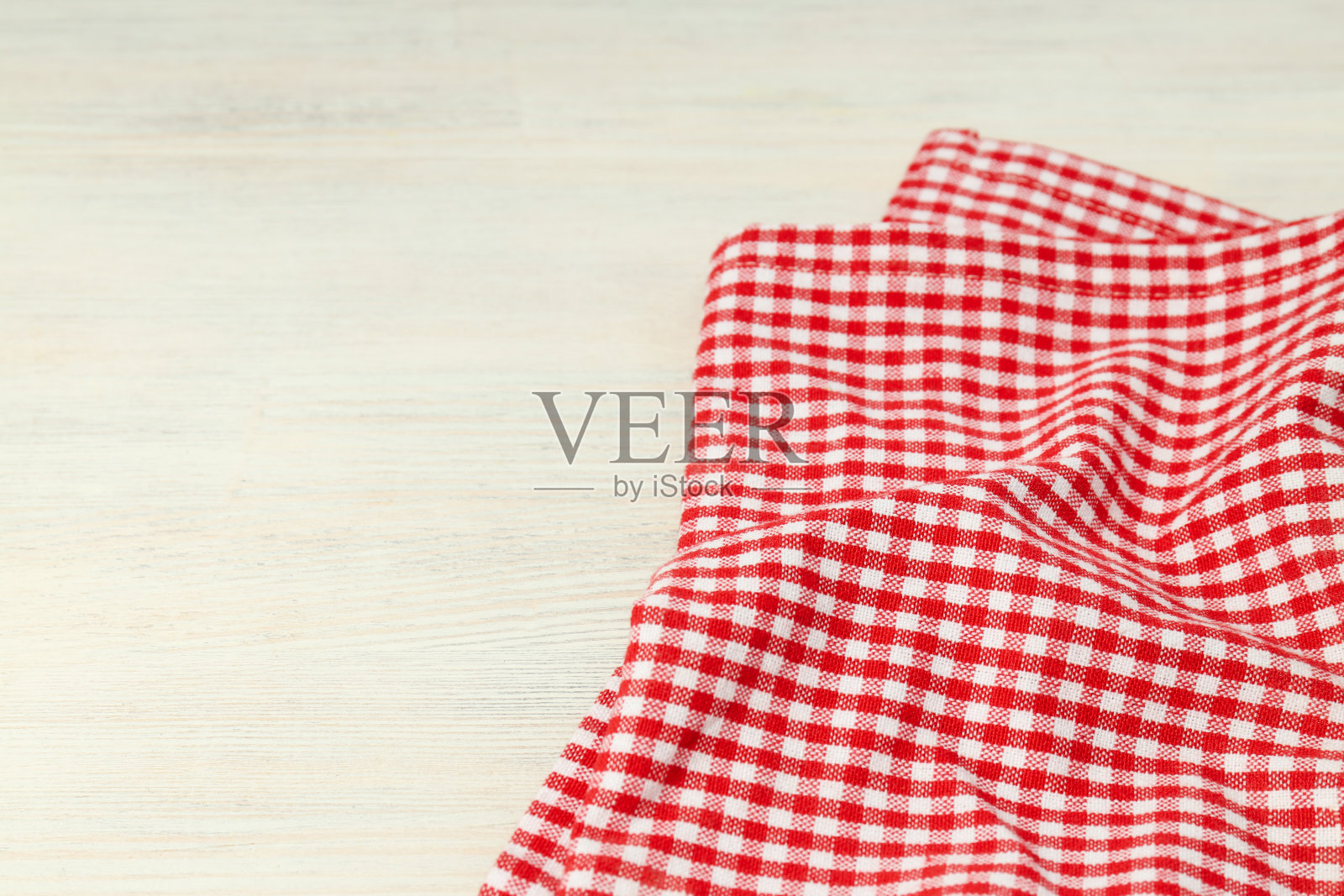 白色木制背景上的红白格子桌布照片摄影图片