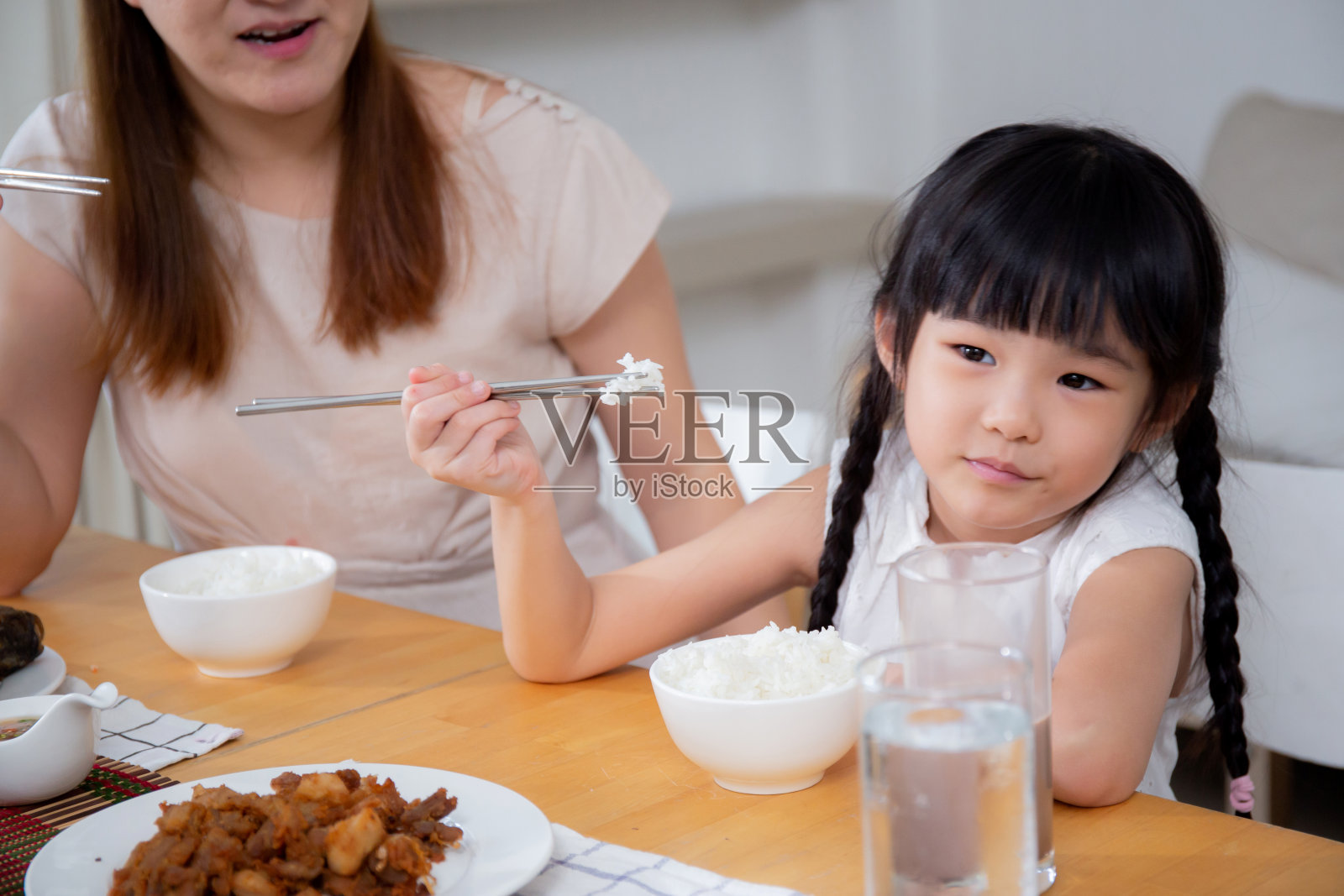 幸福的亚洲家庭，母亲和女儿在家一起在厨房吃饭，父母和孩子坐在客厅吃饭，亲密和关系，生活方式和营养理念。照片摄影图片