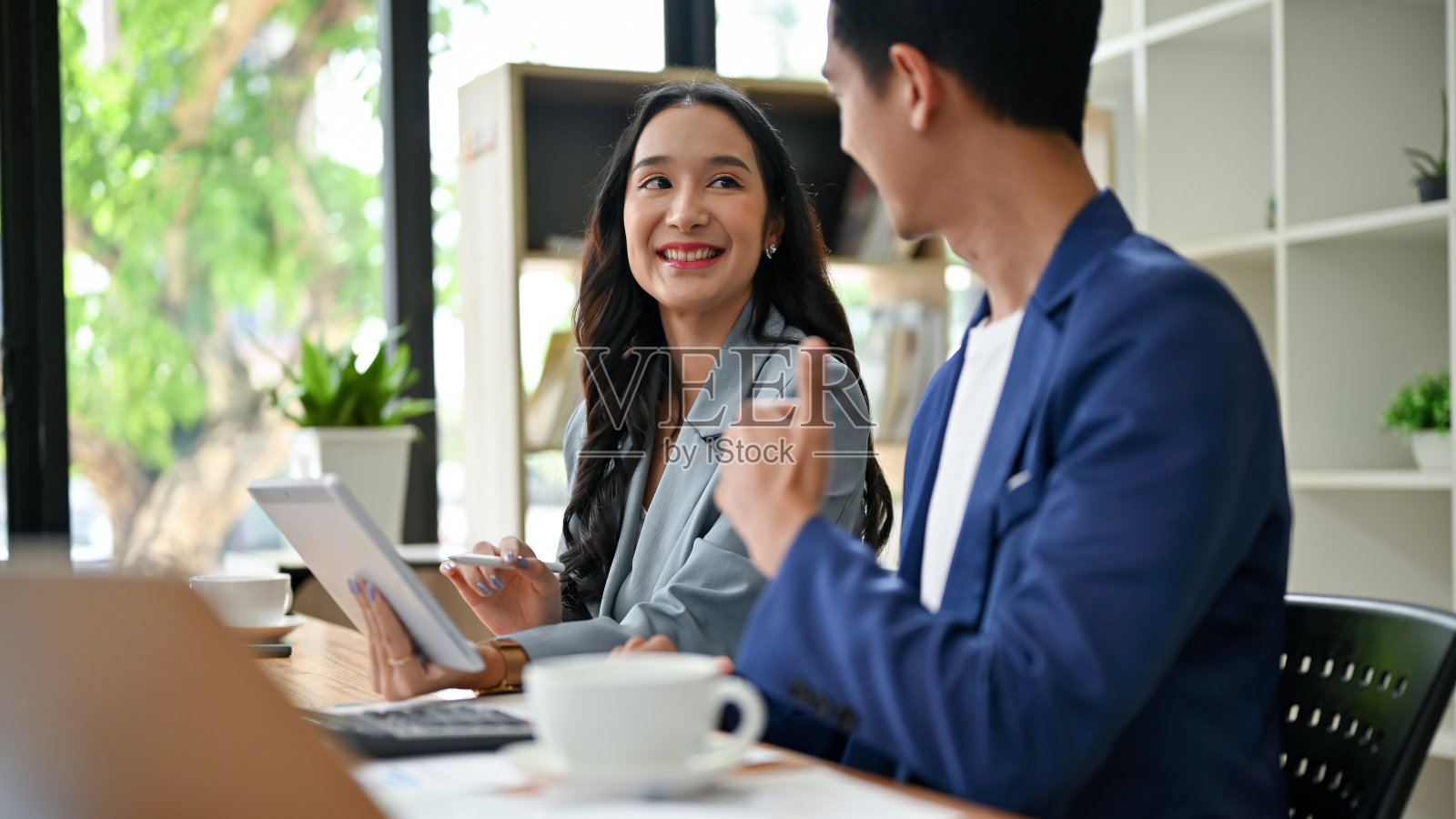 一位女商人正在做一个新项目，一位男同事称赞她照片摄影图片