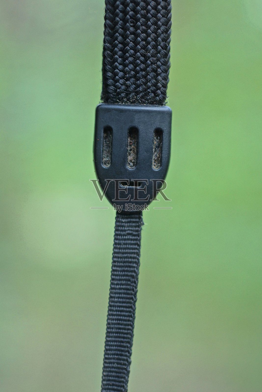 一个小的黑色塑料锁扣锁在一个薄的织物制成的安全带照片摄影图片