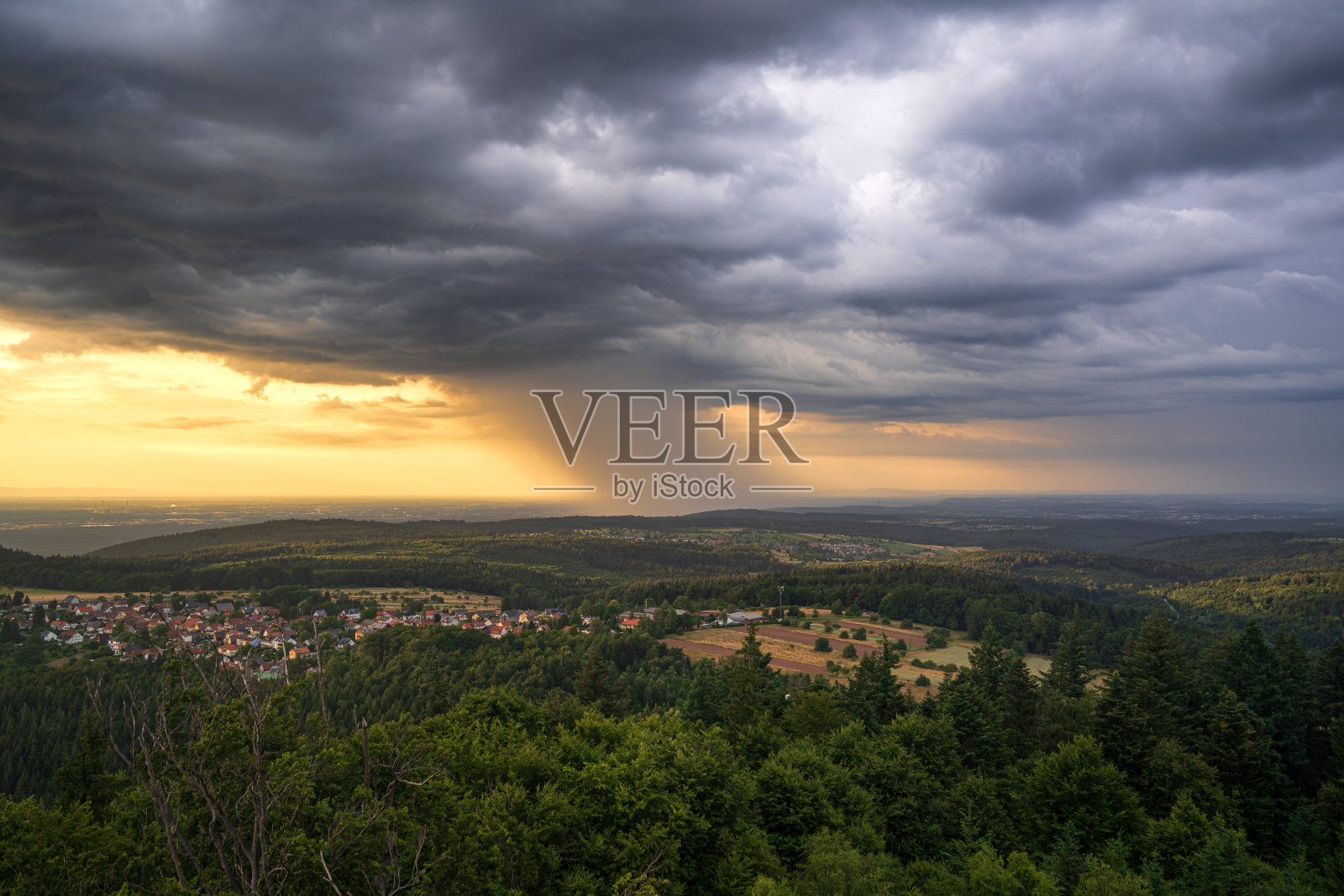 在黄金时段，一场夏季雷暴伴随着大雨在卡尔斯鲁厄市上空移动照片摄影图片
