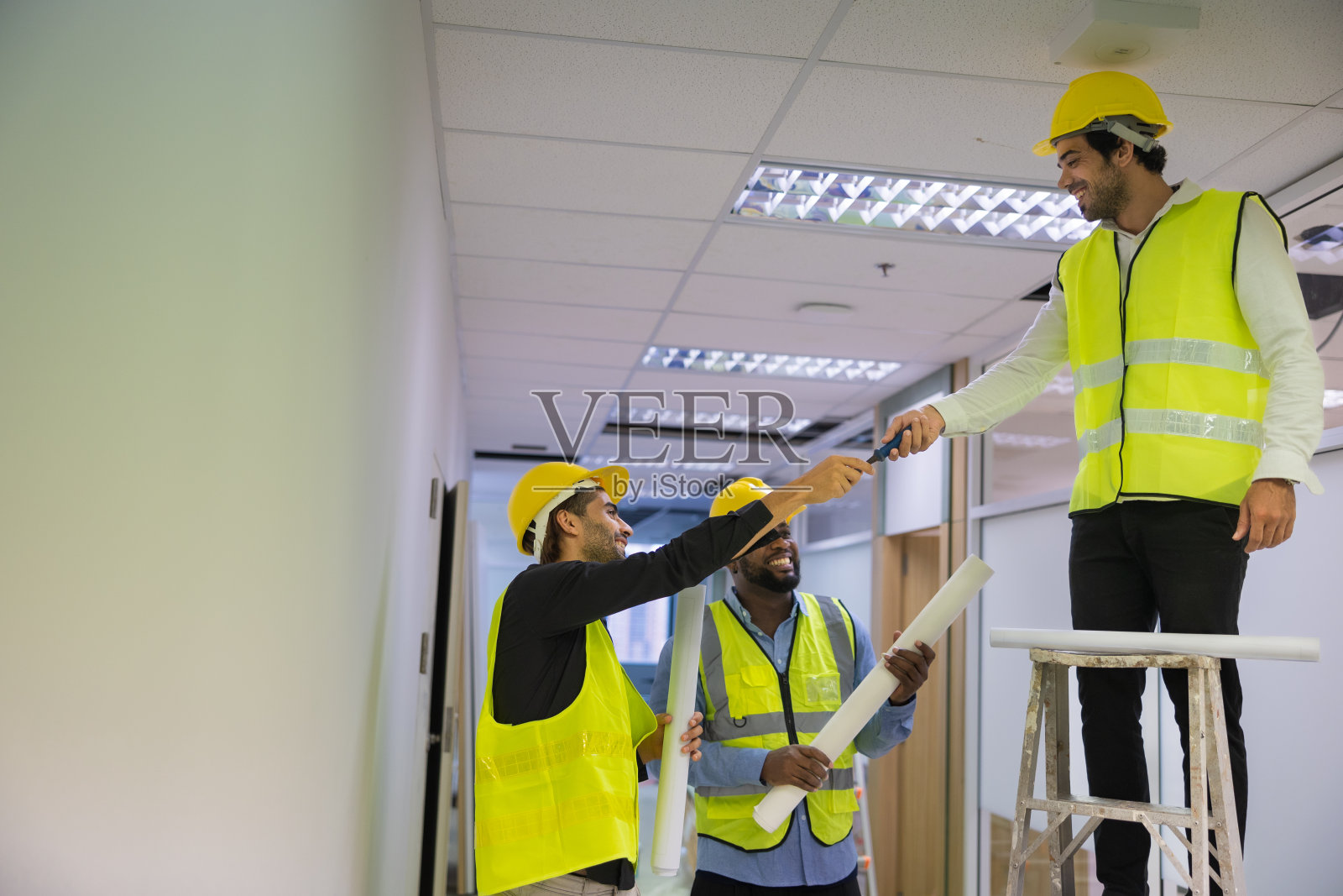 工程师爬梯子修理建筑物天花板照片摄影图片