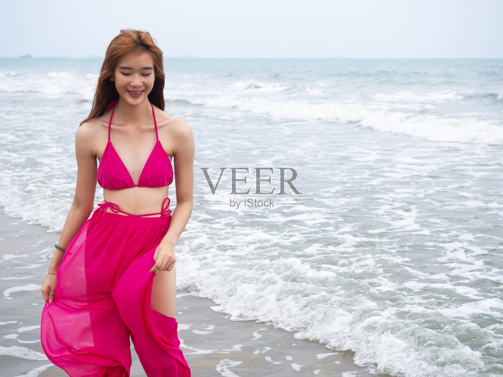 小女孩坐在沙滩上。海运。热带海滩。照片摄影图片