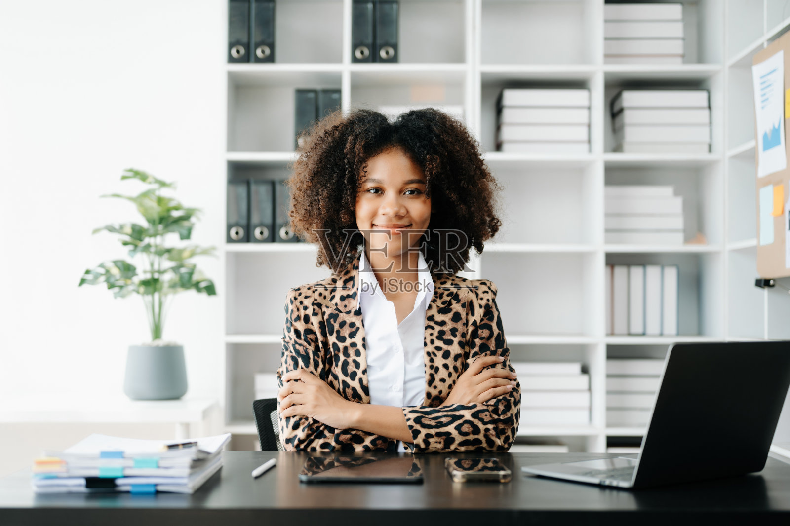 年轻漂亮的女人坐在她的工作场所使用笔记本电脑和平板电脑。专心工作。照片摄影图片