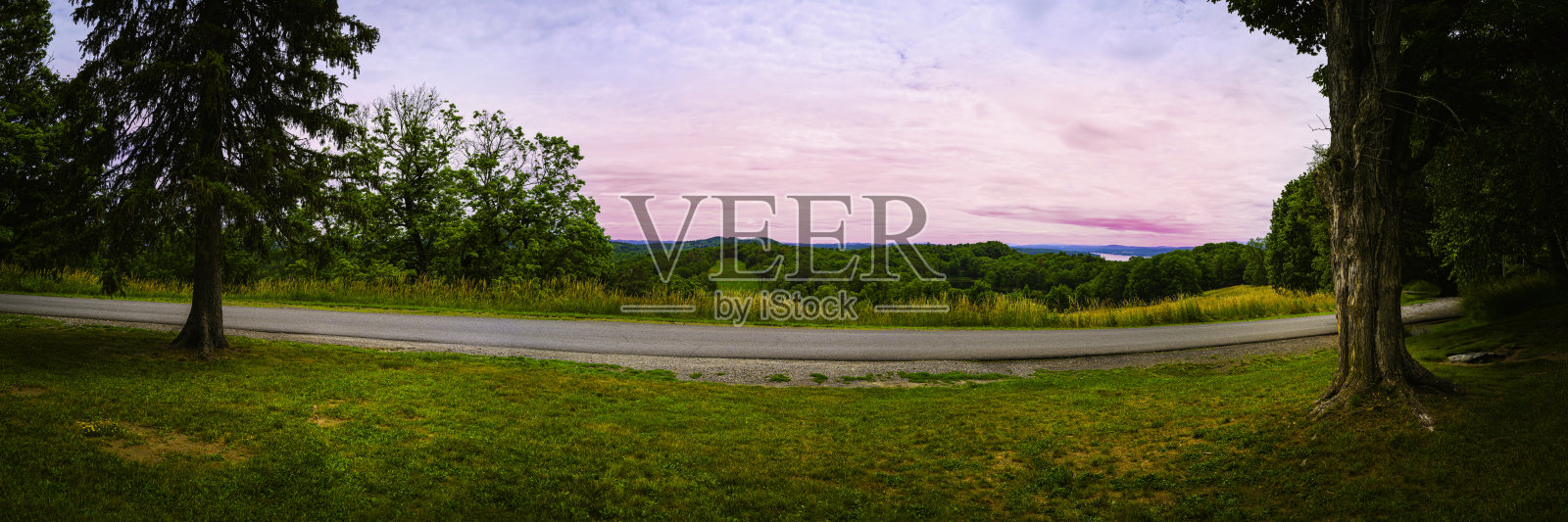 纽约北部哈德逊山谷的丘陵草地和森林与铺砌的道路上的全景日落照片摄影图片