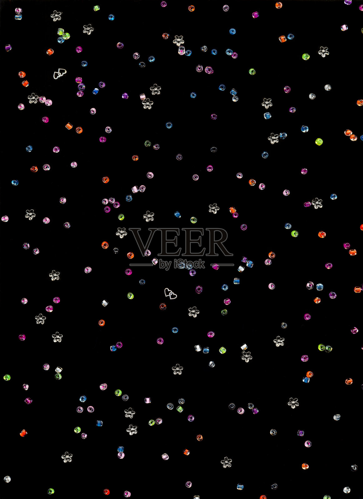 彩色玻璃和花珠散落在黑色背景上，俯视图照片摄影图片