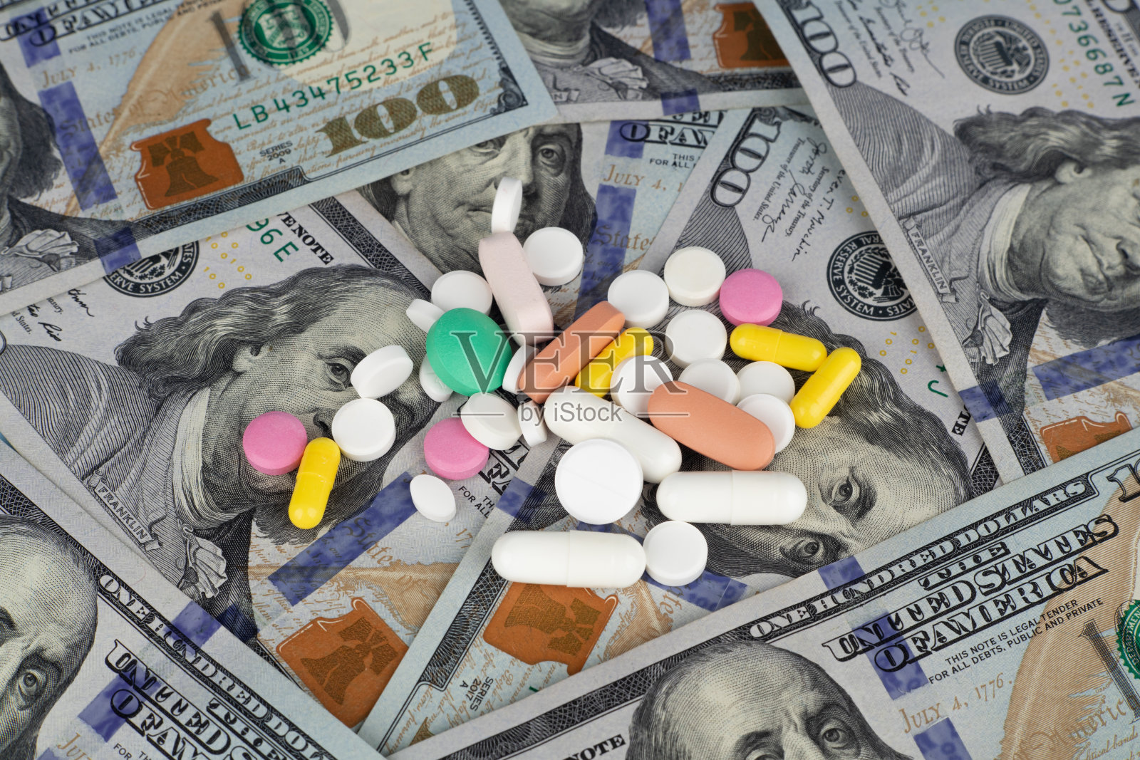 百元美钞的背景是药片。昂贵药品的概念。照片摄影图片