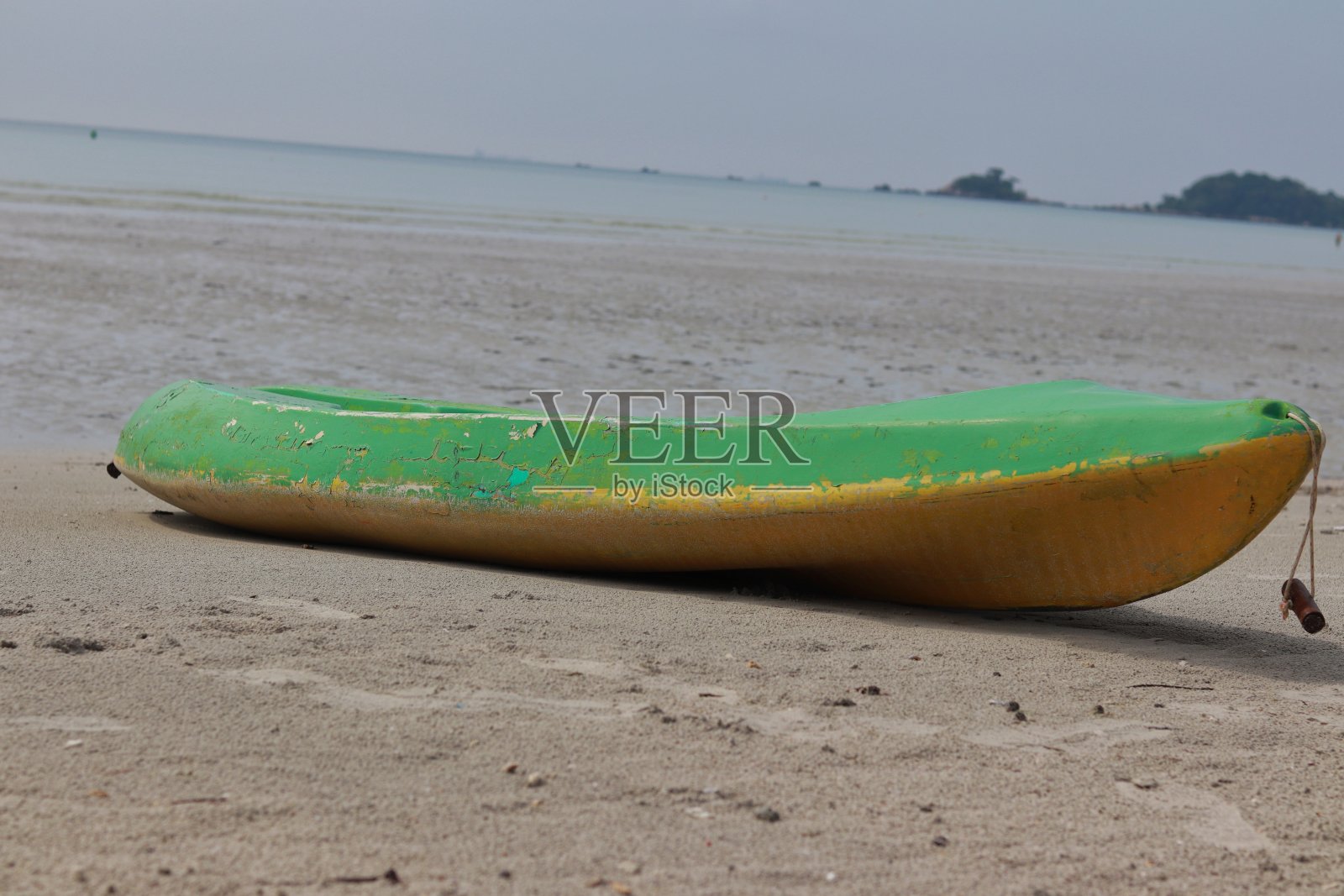 海滩上的绿色皮艇。水上运动交通照片摄影图片