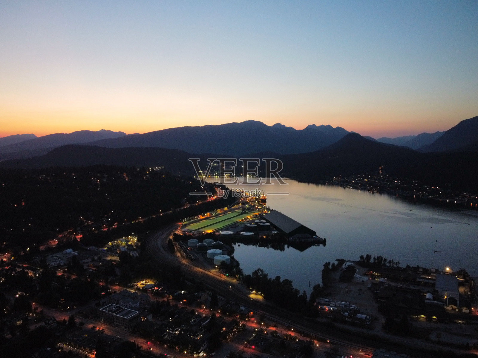 黄昏时分的城市，从山顶俯瞰一片水域照片摄影图片