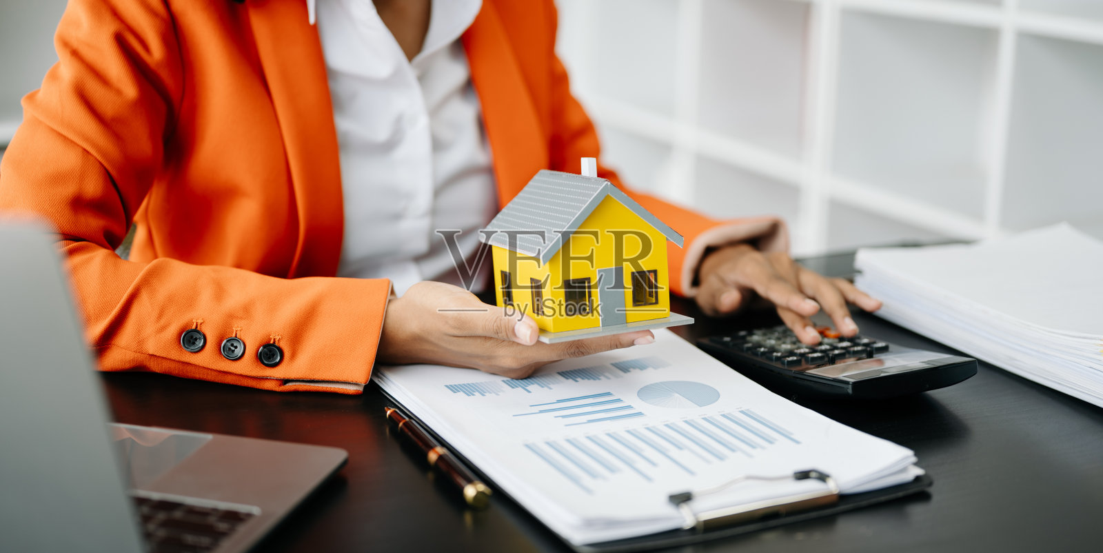 房地产经纪人向客户提出并咨询决策签订保险合同、房屋模型、有关按揭贷款报价照片摄影图片