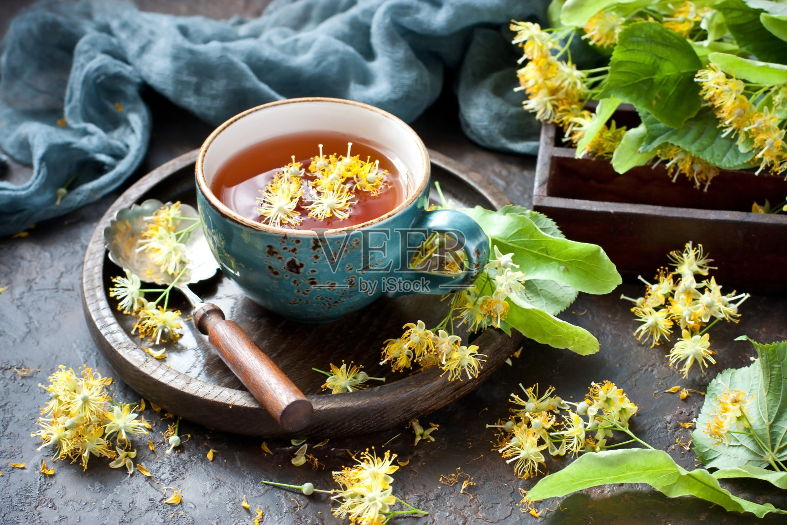 深色的桌子上，一杯菩提茶和鲜花照片摄影图片