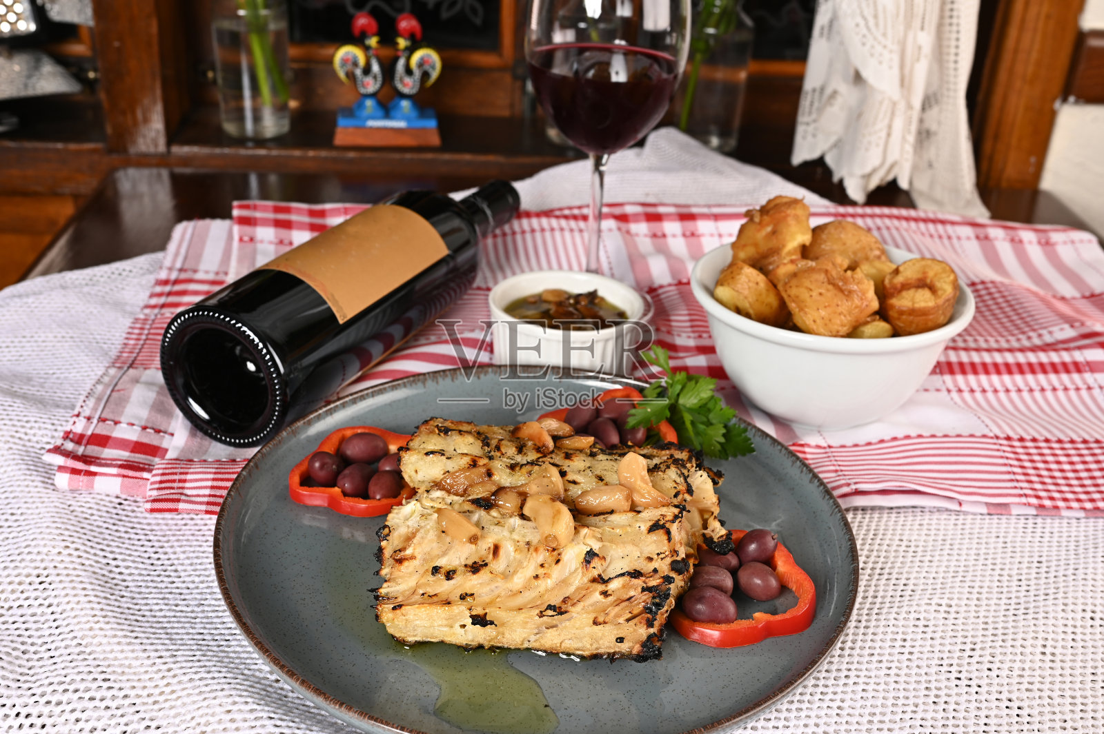 典型的葡萄牙菜烤鳕鱼配洋葱蒜椒和质朴的巴巴塔尼亚食物照片摄影图片