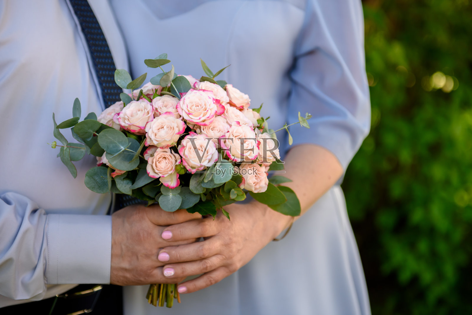 新娘的捧花在新娘和新郎的手中。照片摄影图片