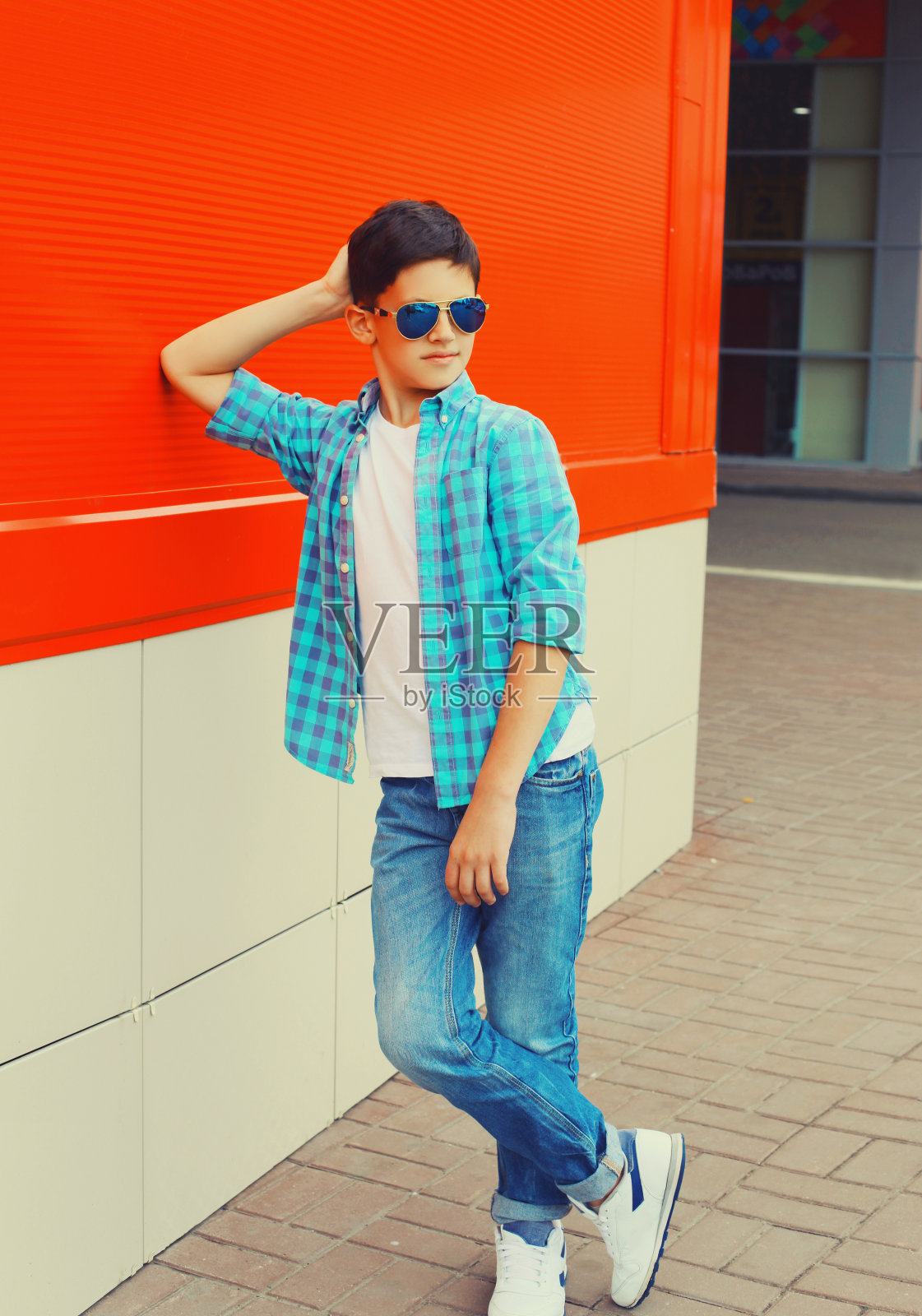 十几岁的男孩戴着太阳镜，穿着衬衫在城市街道上摆姿势照片摄影图片