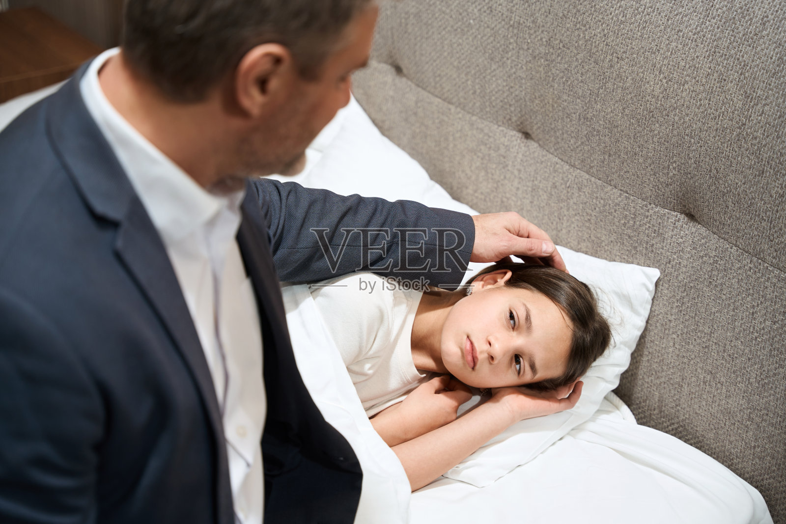 成年男子在卧室哄女儿睡觉照片摄影图片