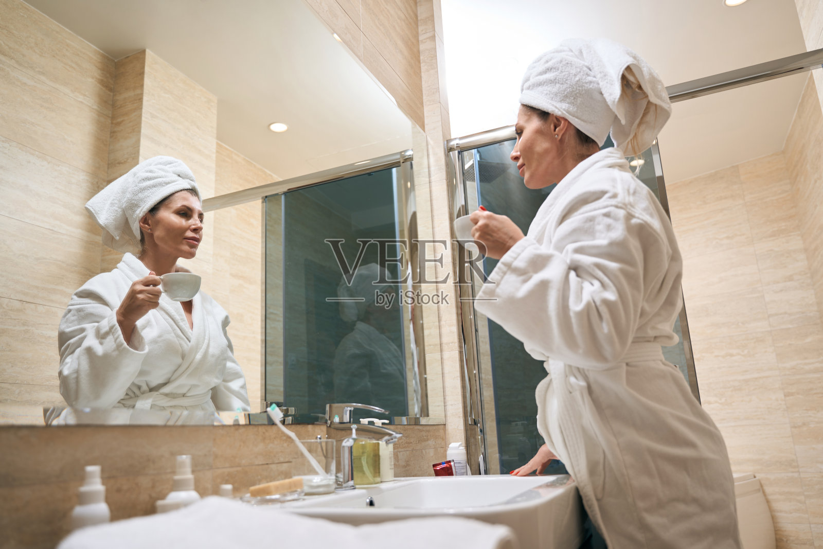 年轻女子在浴室喝茶照片摄影图片