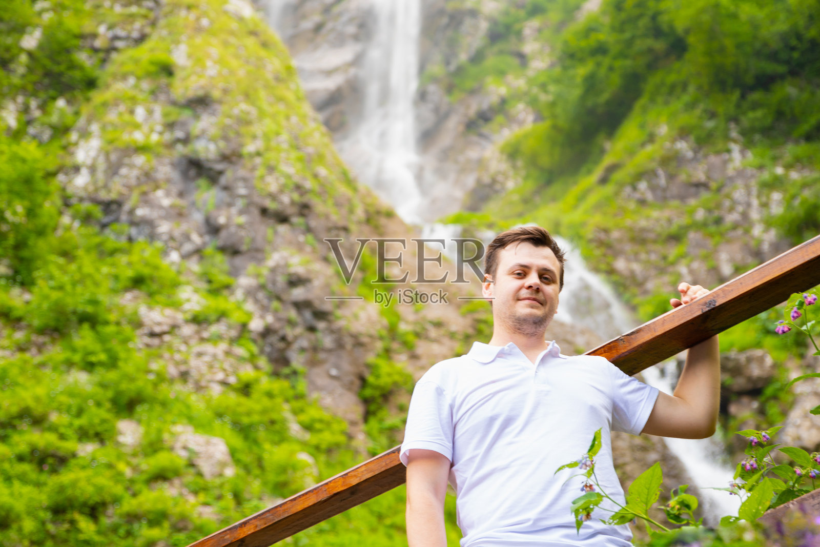 男男上自然山瀑布。中年成年欧洲白种人。夏季远足、公园休闲活动。看着镜头34岁的游客。生活方式的肖像。照片摄影图片