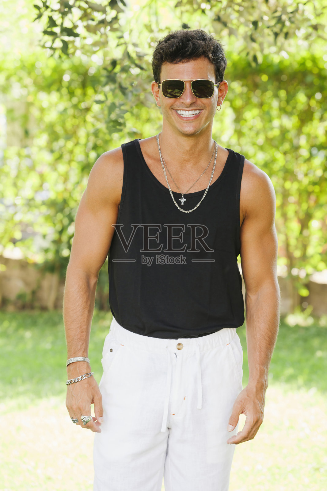 自信时尚的男人站在绿色的花园里照片摄影图片