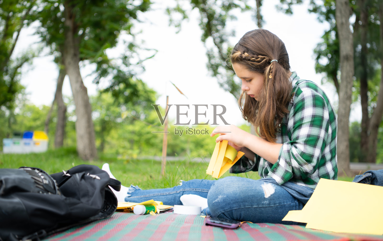 小女孩在公园度假，用纸做鸟嘴的手艺可以用你的手指移动你的嘴。照片摄影图片
