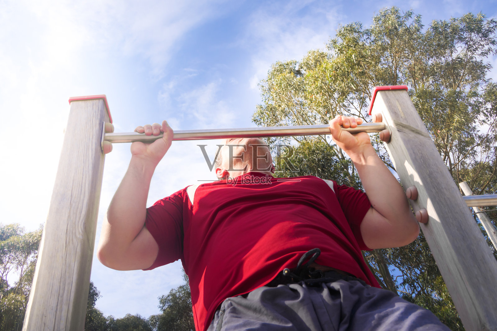 强壮的肌肉男在公园里做引体向上照片摄影图片