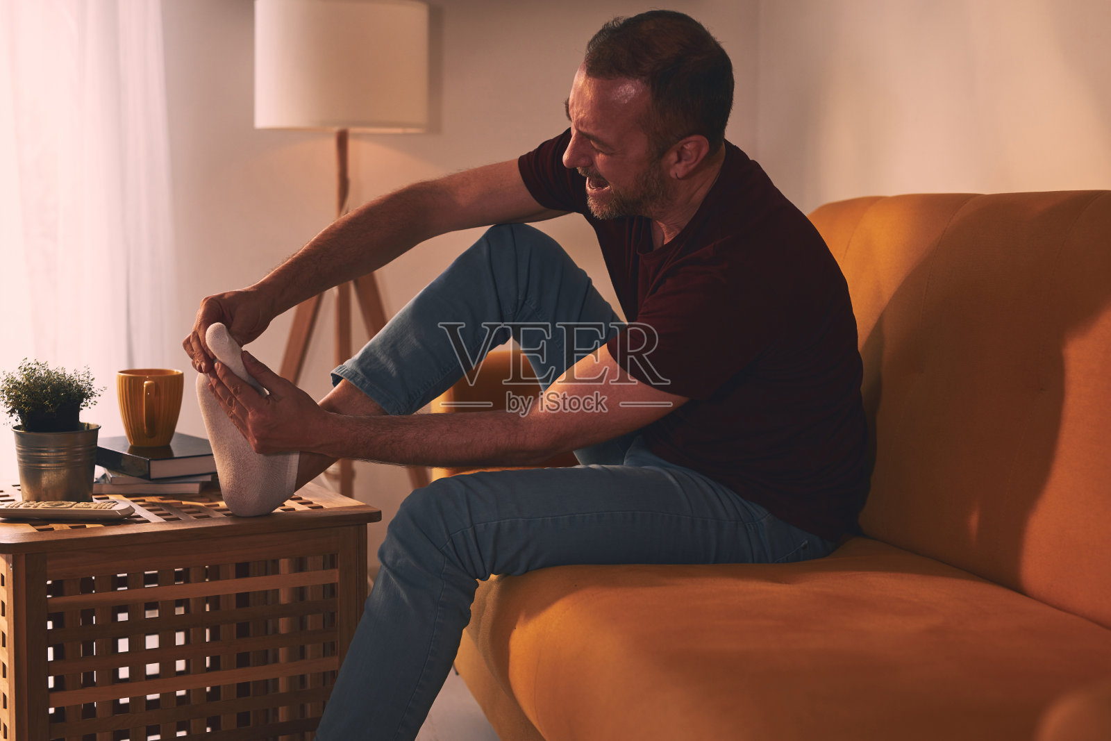 家里有脚痛的男人。照片摄影图片