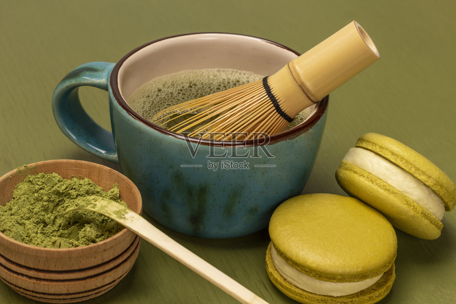 绿色抹茶粉和量勺放在木碗里。绿杏仁饼干。照片摄影图片