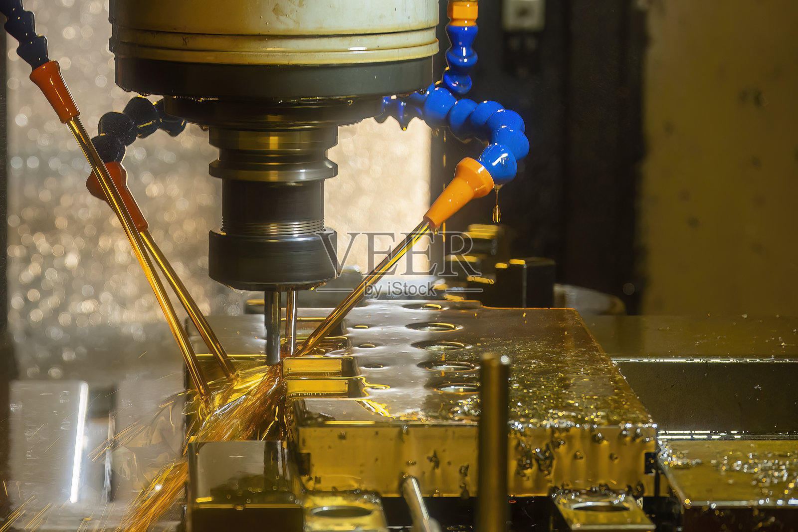 数控铣床采用油冷却液法切割模具底座零件。照片摄影图片