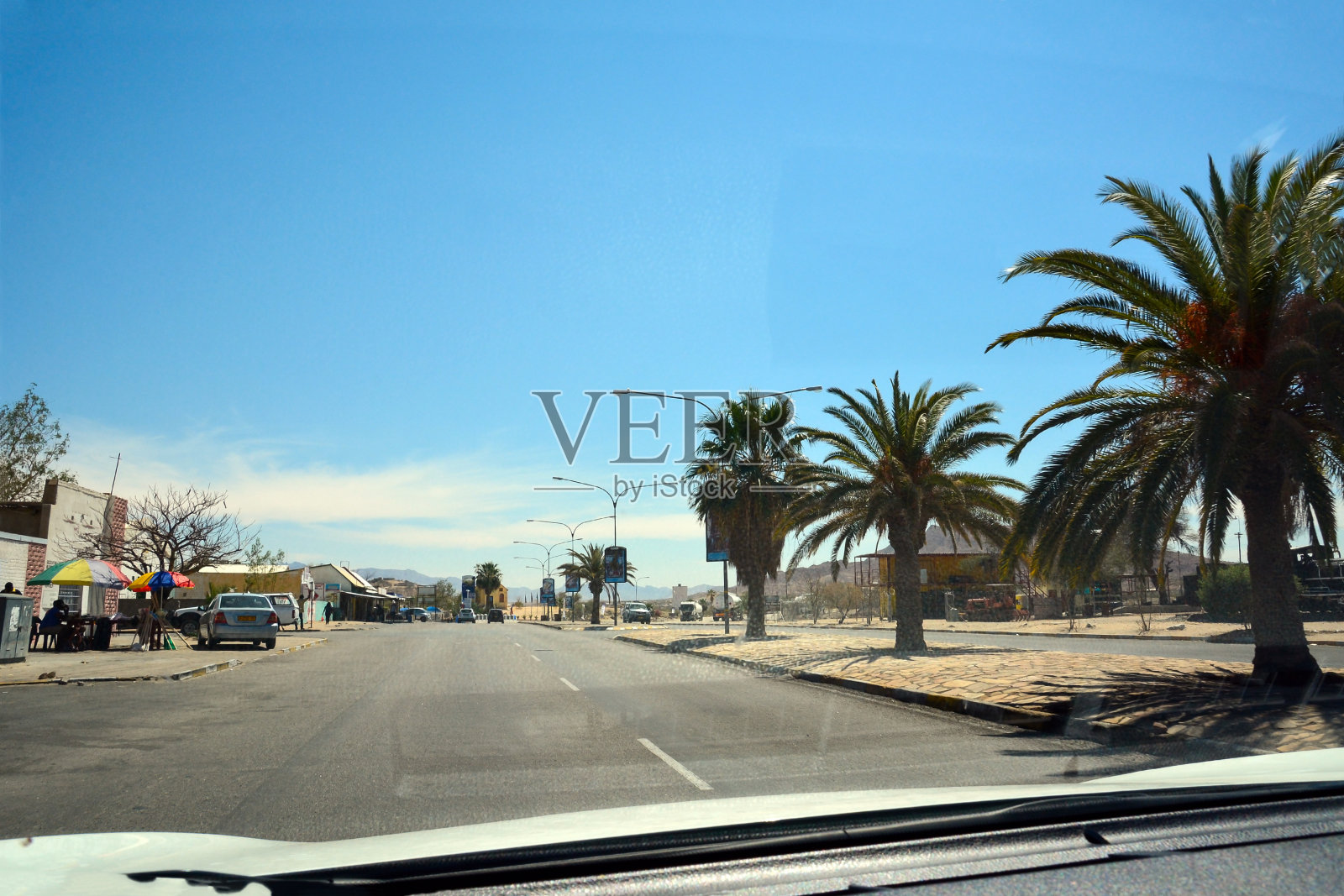 从汽车上看道路上的透视在一个小镇上的透视。炎热的气候和沙漠景观照片摄影图片