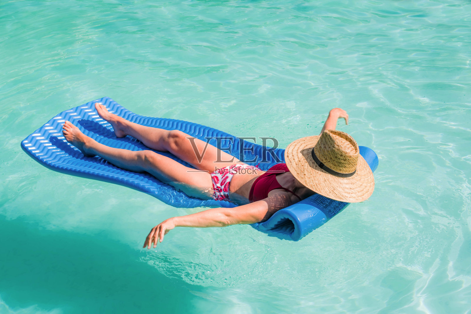中年妇女懒洋洋地躺在水里的床垫上照片摄影图片